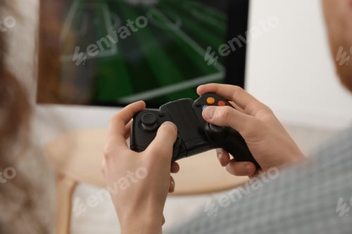 Preview: Young man playing video games at home, closeup