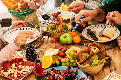 Preview: Hands of family dining withpicking food with fork on dining table. Sliced meat, christmas time