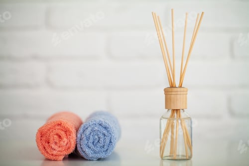 Preview: Fluffy bath towels on light wooden table with aroma sticks