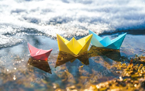 Preview: Multicolored paper boats. Colorful pink yellow blue orange ships in big spring snow puddle on