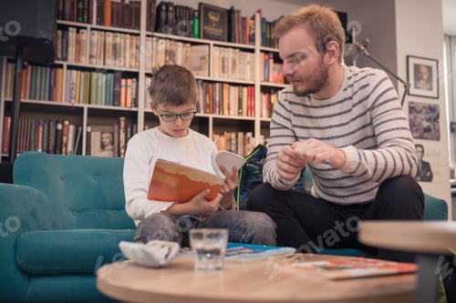 Preview: Father And Son Doing Homework Together In Living Room