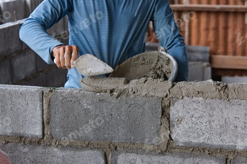 Preview: Bricklayer laying bricks on mortar