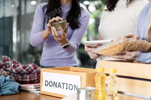 Preview: Volunteers organizing donations at a community event, collecting food