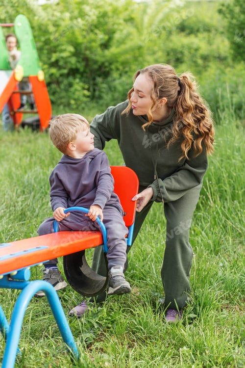 Preview: Mother and Kid on Seesaw in Park. Playtime.