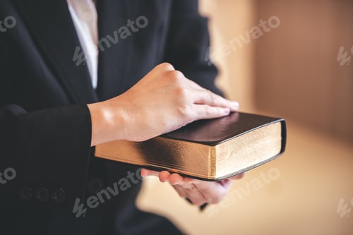 Preview: focus on woman's hand While praying for Christianity with blurry body background, casual woman prays