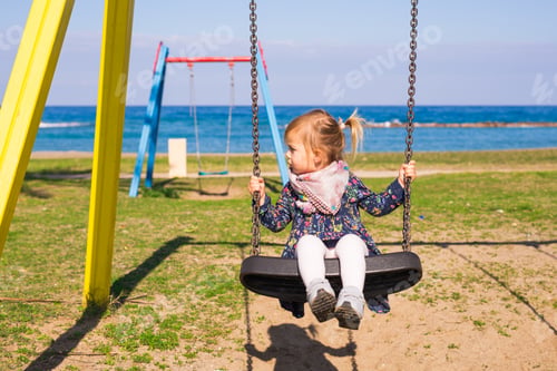 Preview: summer, childhood, leisure and people concept - happy little girl on children playground