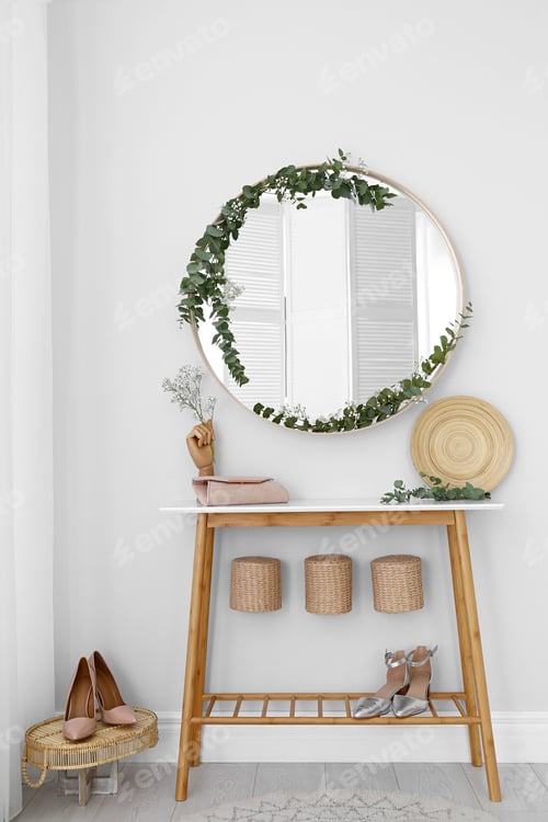 Preview: Round mirror and table with accessories near white wall. Modern interior design