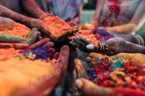 Preview: close-up partial view of young people holding colorful powder in hands at holi festival