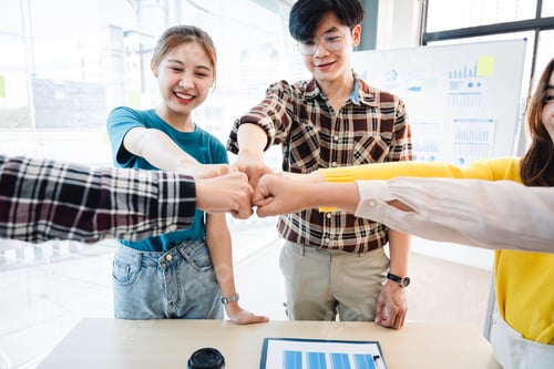 Preview: young business people putting their hands together. Stack of hands. Unity and teamwork concept.