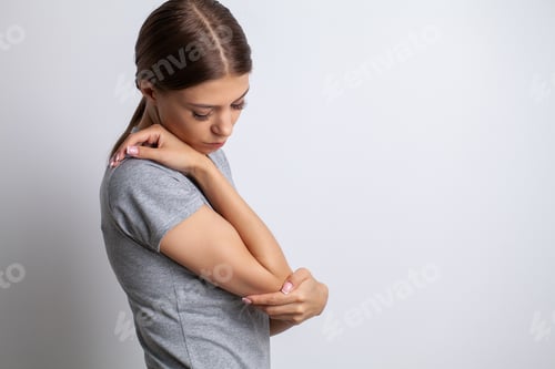 Preview: elbow pain woman suffering from elbow pain on gray background