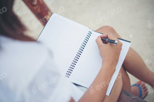 Preview: Close up of woman hand writing on notepad.
