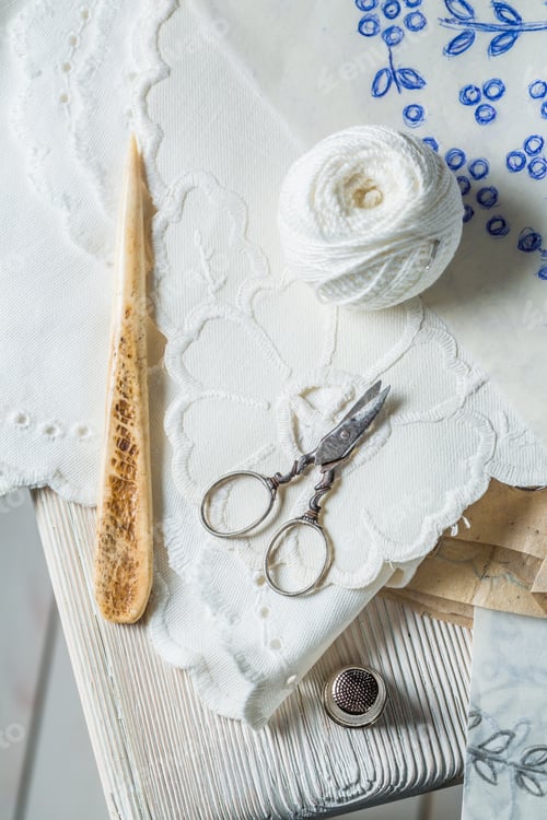 Preview: White thread, scissors and homemade embroidered napkins