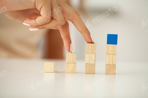 Preview: Woman hand putting and stacking blank wooden cubes on desk with copy space