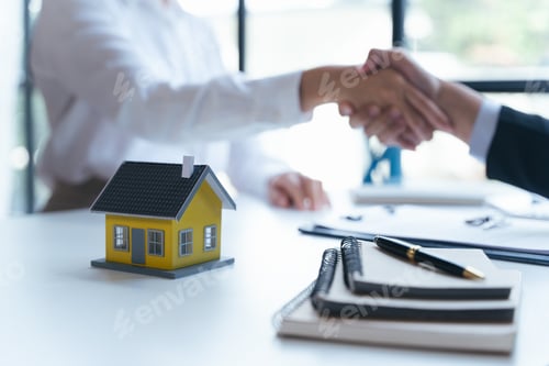 Preview: Agent and client shaking hands after signed document and done business deal