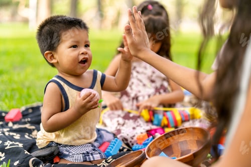 Preview: Toddler giving high five playing with family in park
