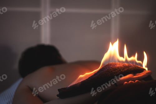 Preview: Fire flame massage alternative therapy. Fire on male back in dark room