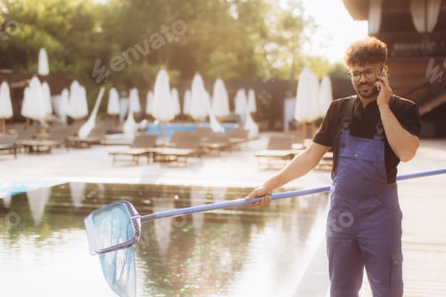 Pool cleaner talking on phone while holding cleaning net