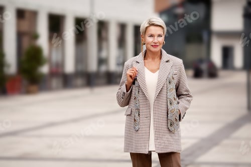 Preview: Portrait of beautiful mature business woman fashionably dressed in jacket and tie, standing street