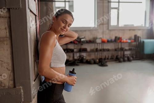 Preview: Young woman resting after training in the gym, smiling