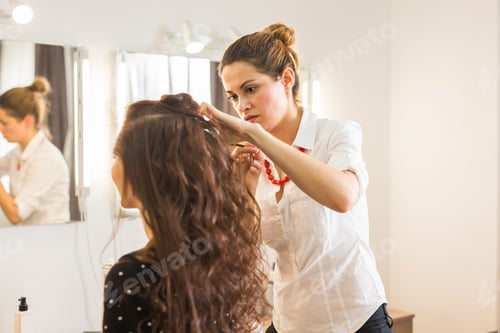 Preview: working day inside the beauty salon. Hairdresser makes hair styling.