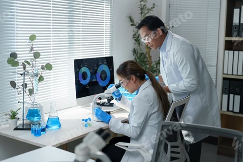 Preview: Scientists wearing lab coats and protective eyewear work in a laboratory.
