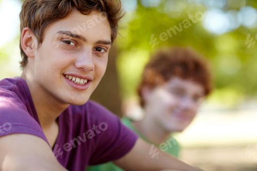 Preview: Enjoying the fresh air. Portrait of two teenage boys sitting in a park on a sunny day.