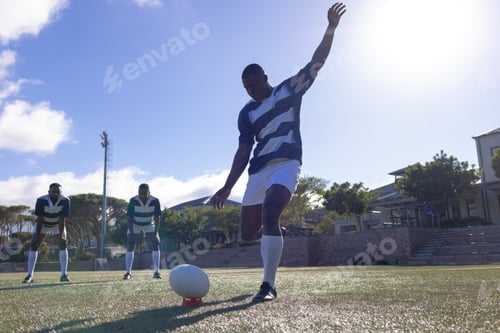 Preview: Three African American young male athletes playing rugby on a sunny field, copy space