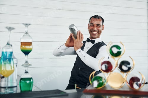 Preview: At the bar. Black waiter in formal clothes is at his work outdoors at sunny daytime