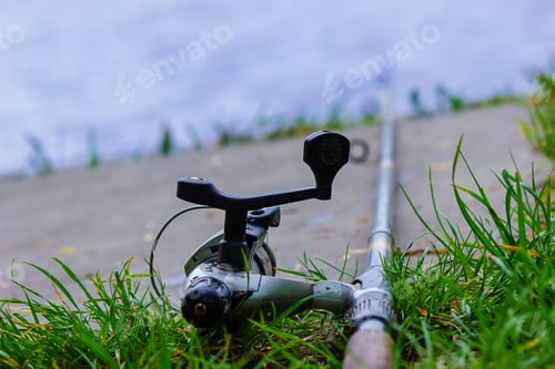 Preview: Fishing rod and accessories for fishing on the grass. Selective focus.