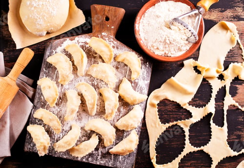 Preview: Raw dumplings varenik - traditional Ukrainian food - on wooden board close up.