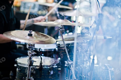 Preview: Drummer play at drum set on stage in a concert hall behing glass wall.