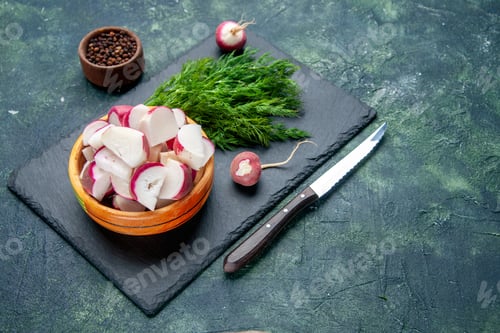 Preview: Side view of fresh dill bundle and whole chopped radishes knife on black cutting board pepper knife