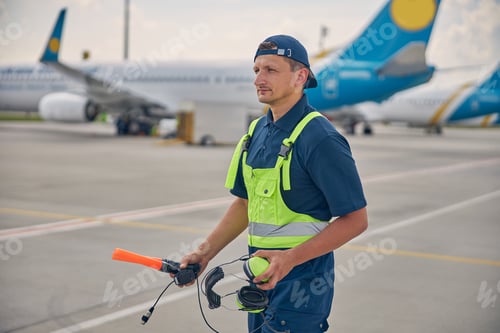 Preview: Airport worker gazing fixedly into the distance