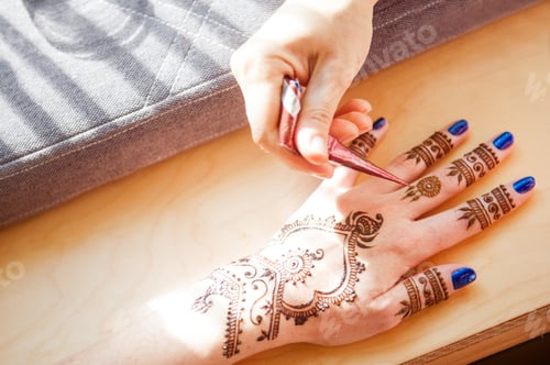 Preview: Drawing mehndi on the hand of a girl