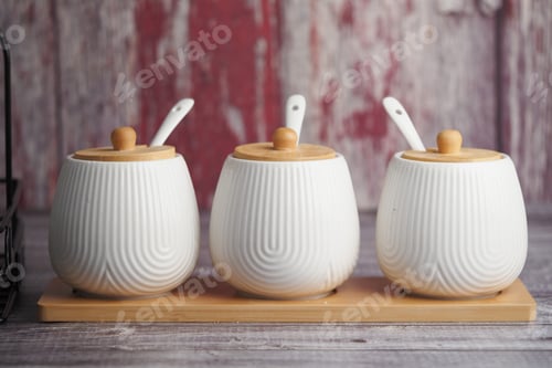 Preview: Stylish ceramic condiment holders on wooden tray in rustic setting