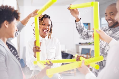 Preview: Colleagues in team building task holding yellow rubes smiling