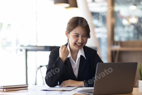 Preview: Attractive Asian businesswoman in the office working with financial documents on the desk.