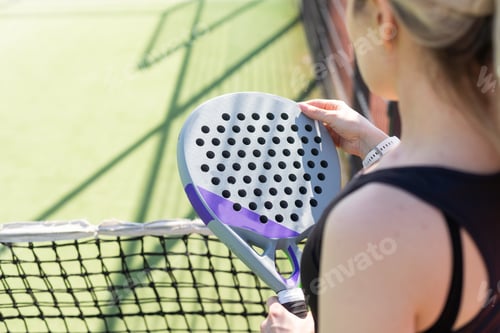 Preview: hands of a woman paddle player is holding balls and the racket at the background at the beginning of