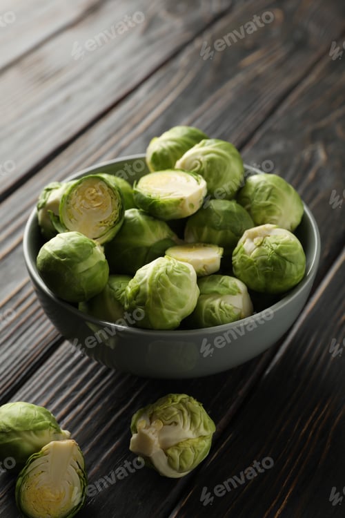 Preview: Bowl with brussels sprout on wooden background, space for text