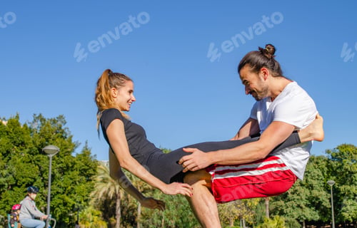 Preview: Happy Young Couple Having Fun Practicing Acro Yoga Pose at the Park in Valentin's Day