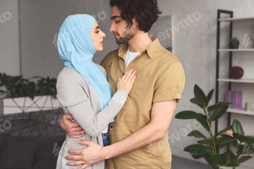 Preview: affectionate muslim couple hugging at home