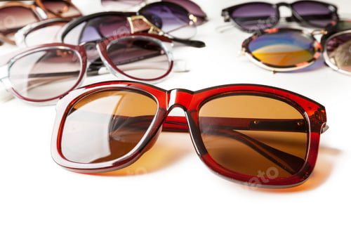 Preview: Collection of sunglasses displayed on a white surface in a bright room at midday