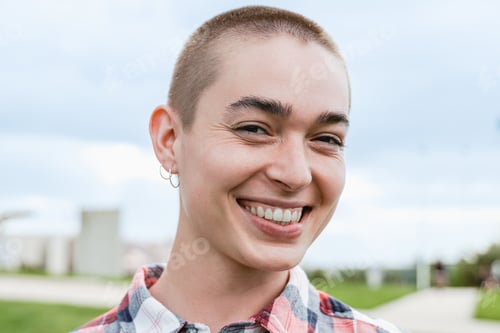 Preview: Portrait of young bald woman smiling on camera outdoor at park city - Focus on face