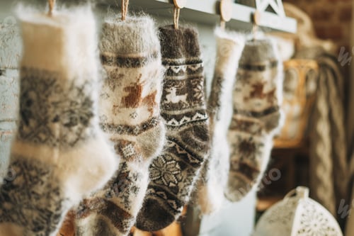Preview: Cozy fluffy wool knitted warm socks with reindeer over the fireplace in the cottage