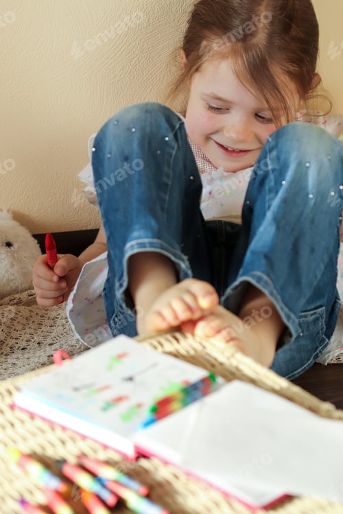 Preview: A little girl 6 years old is resting and thinking about a plot for drawing