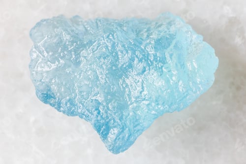 Preview: sample of raw aquamarine mineral on white marble