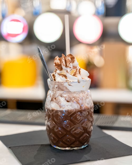 Preview: Vertical shot of a chocolate milkshake with whipping cream in a decorative glass