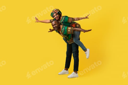 Preview: Loving black man, woman having fun on yellow, full length