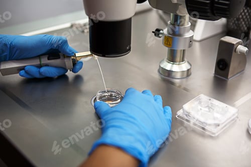 Preview: Hands of a scientist in the laboratory with a test tube and a microscope