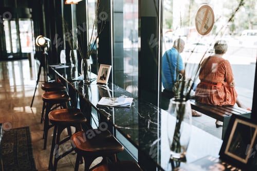 Preview: Tables with chairs are shown,situated next to a glass wall. Lovely atmosphere of the coffee shop is